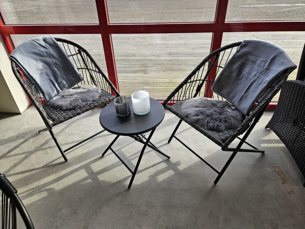 Avkopplande utemöbelhörna för cafébesökare - bekväma stolar och bord för sköna stunder